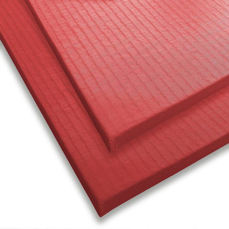Zwei rote Tatami Judomatten übereinandergelegt. Rutschfeste Bodenmatten für sicheres Kampfsporttraining in Dojos.