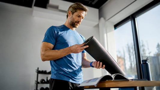 Ein Sportler begutachtet eine ausgerollte Fitnessmatte, die auf dem Tisch liegt.