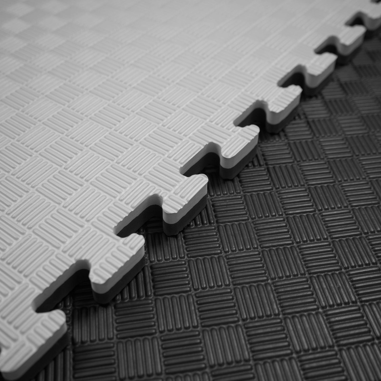 Kampfsport Puzzlematte 100 x 100 cm in Grau und Schwarz mit rutschfester Oberfläche und verzahnten Kanten, ideal für Fitnessräume.